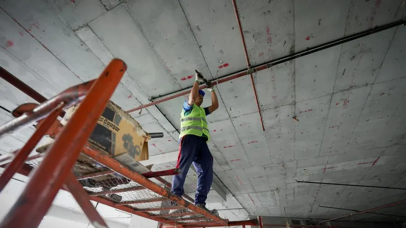 A man standing on a ladder working on a ceiling — stock photo