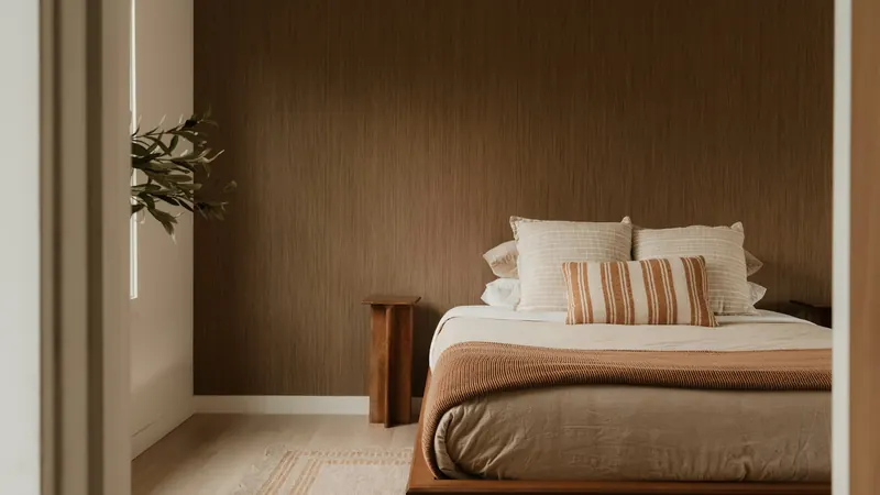 Modern bedroom with bed, pillows, and warm brown wall — stock photo
