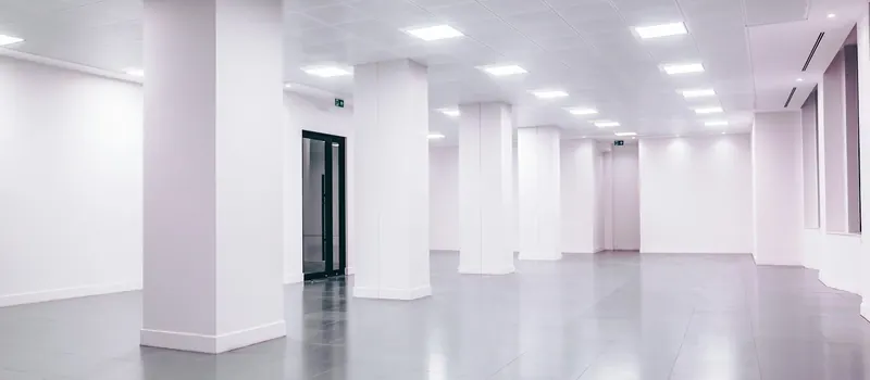 An empty room with white walls and a black door — stock photo