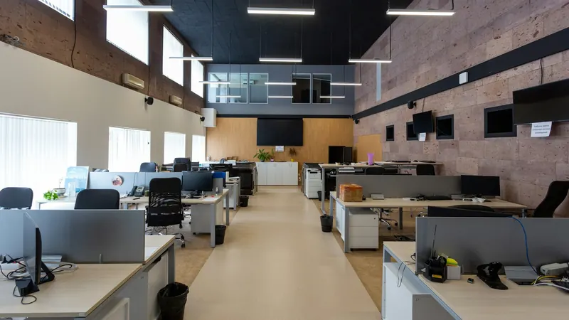Office workspace with rows of desks — stock photo